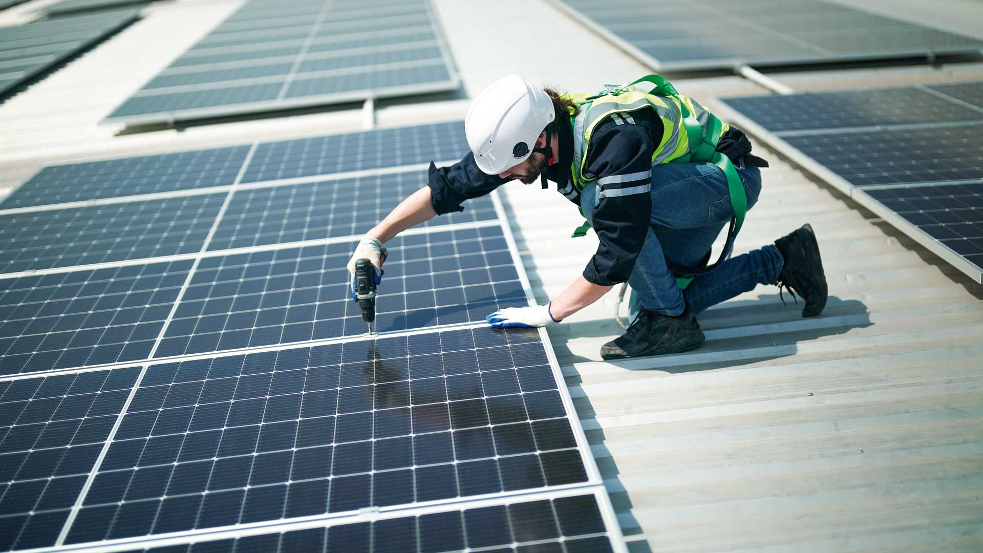 Ingenieur verschraubt Solarpanels auf dem Dach